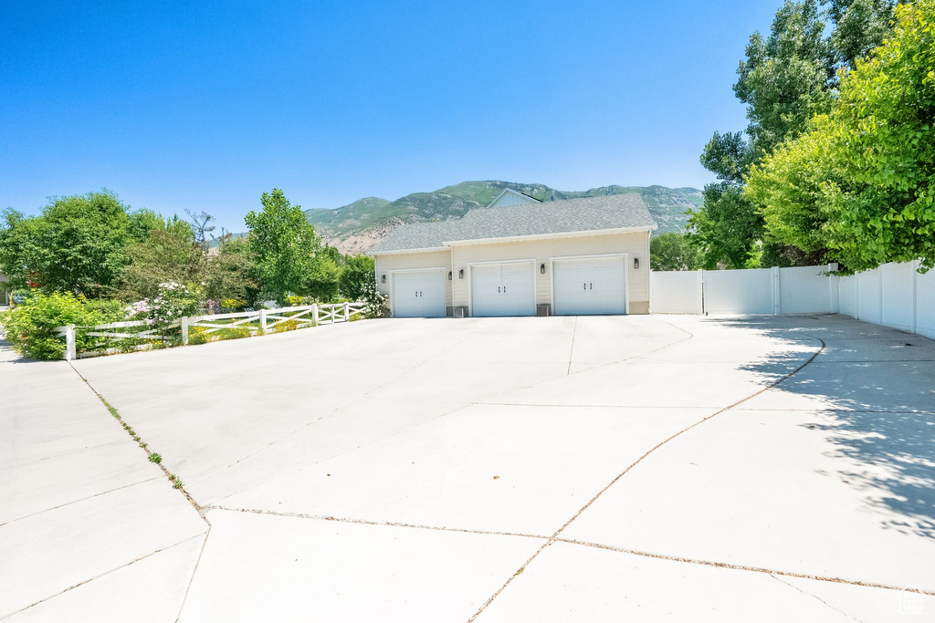 View of side of home featuring a mountain view, a garage, and concrete driveway