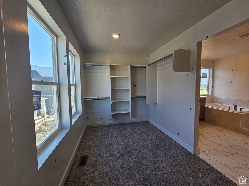 Unfurnished bedroom with a textured ceiling, marble look tile flooring, and recessed lighting