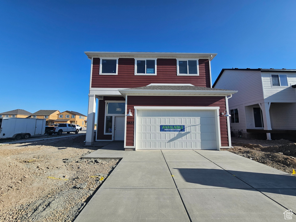 Traditional-style house with concrete driveway and a garage