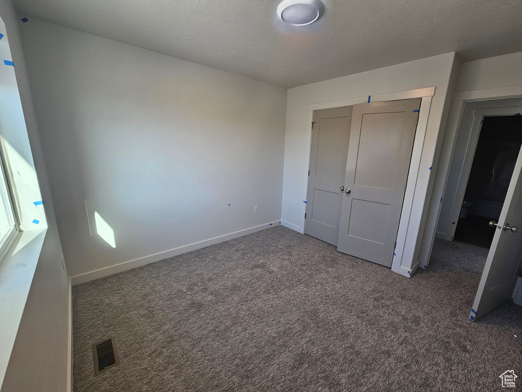 Unfurnished bedroom with carpet and a closet
