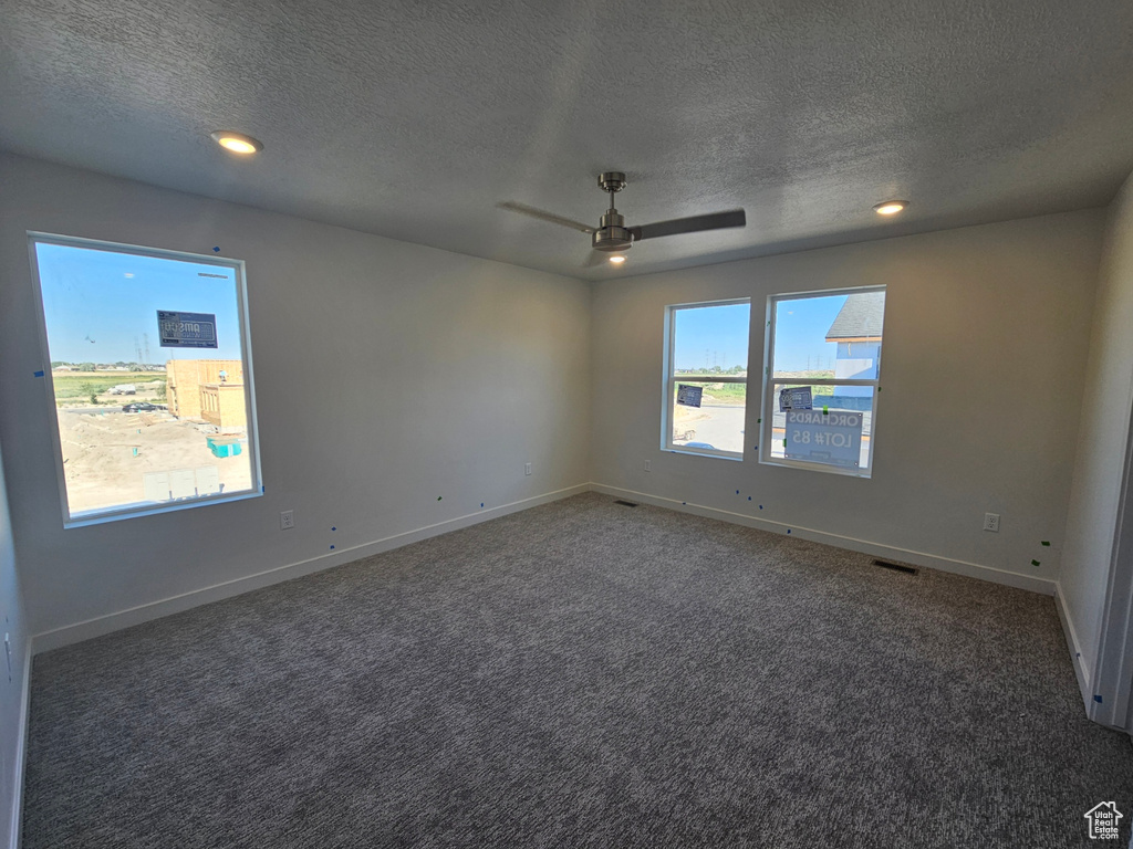 Empty room featuring a textured ceiling, carpet flooring, a ceiling fan, and recessed lighting