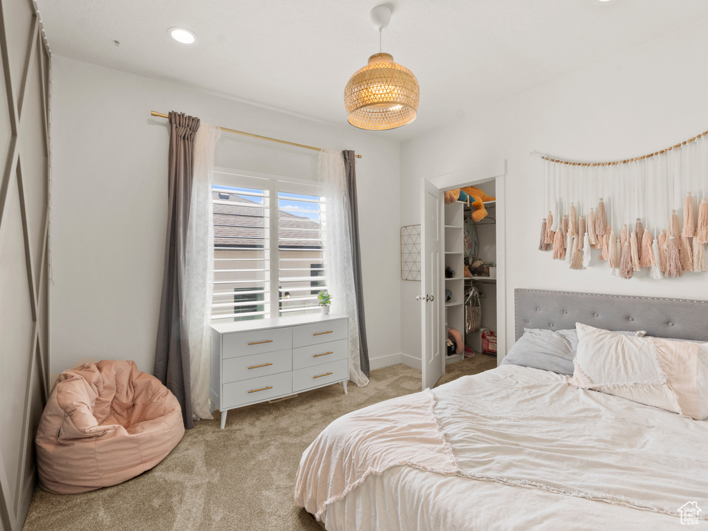 Bedroom with light carpet, a spacious closet, and a closet