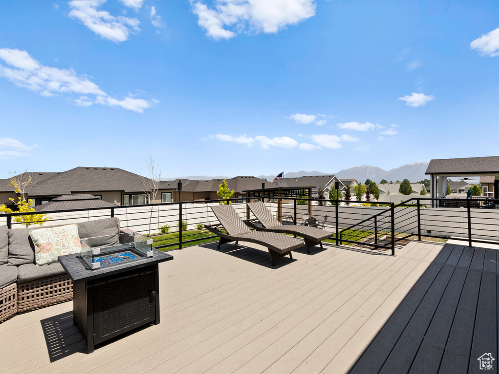 Wooden terrace with a fire pit, a residential view, and a mountain view