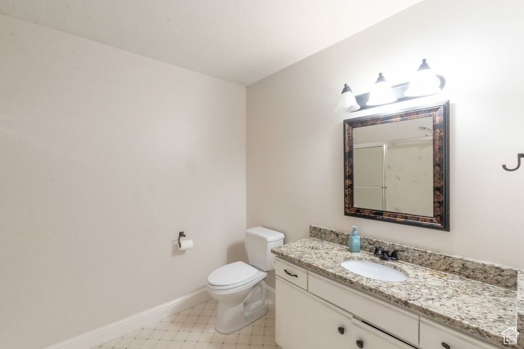 Bathroom featuring vanity, a shower with door, and tile patterned floors