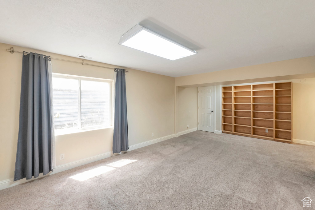 Empty room featuring carpet and baseboards