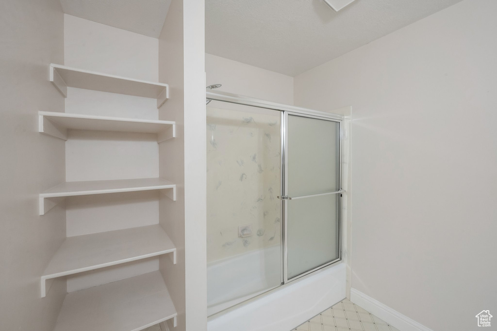 Full bathroom featuring enclosed tub / shower combo and tile patterned floors