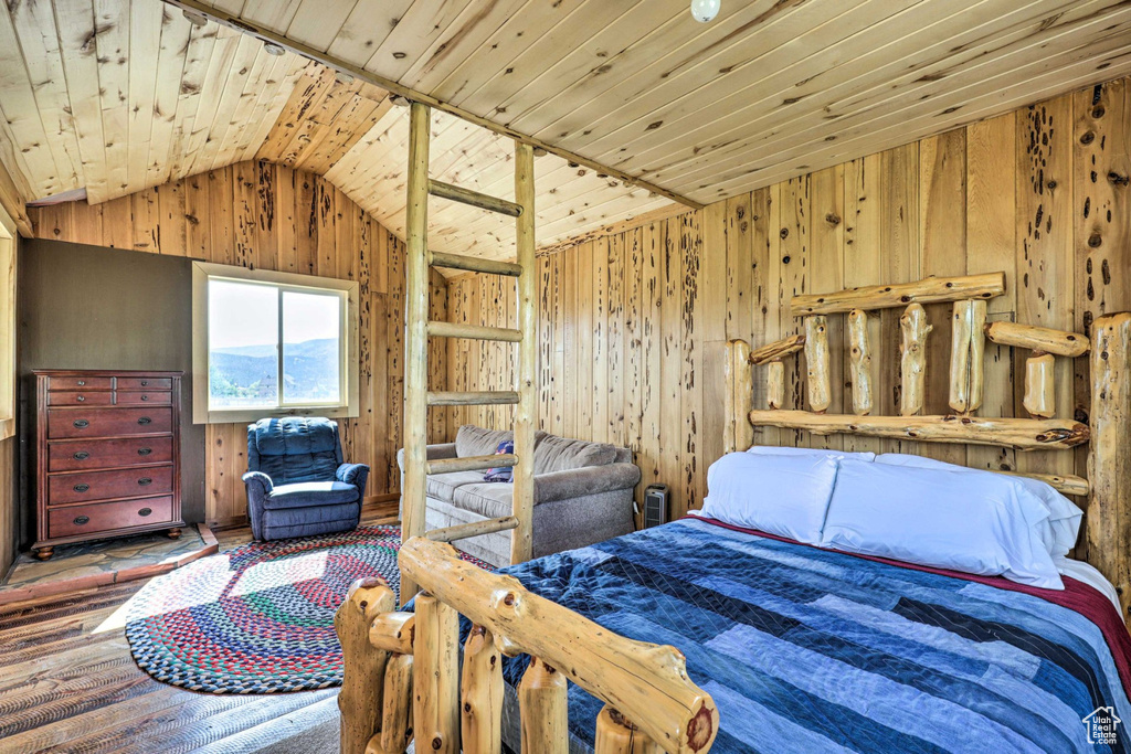 Bedroom featuring lofted ceiling, wood walls, wood ceiling, and hardwood / wood-style floors