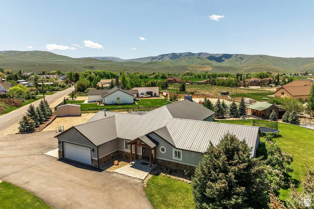 Aerial view of property and surrounding area with a mountain backdrop
