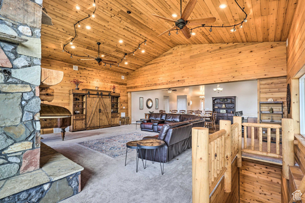 Living area featuring ceiling fan, wooden ceiling, track lighting, high vaulted ceiling, and a barn door