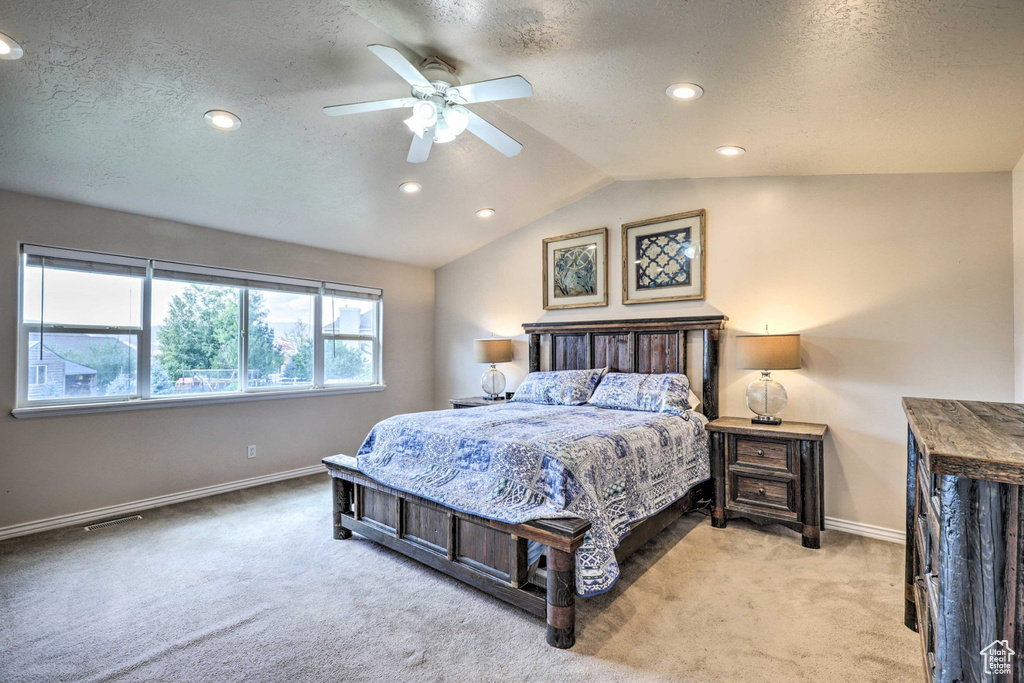 Carpeted bedroom with recessed lighting, a textured ceiling, lofted ceiling, and a ceiling fan