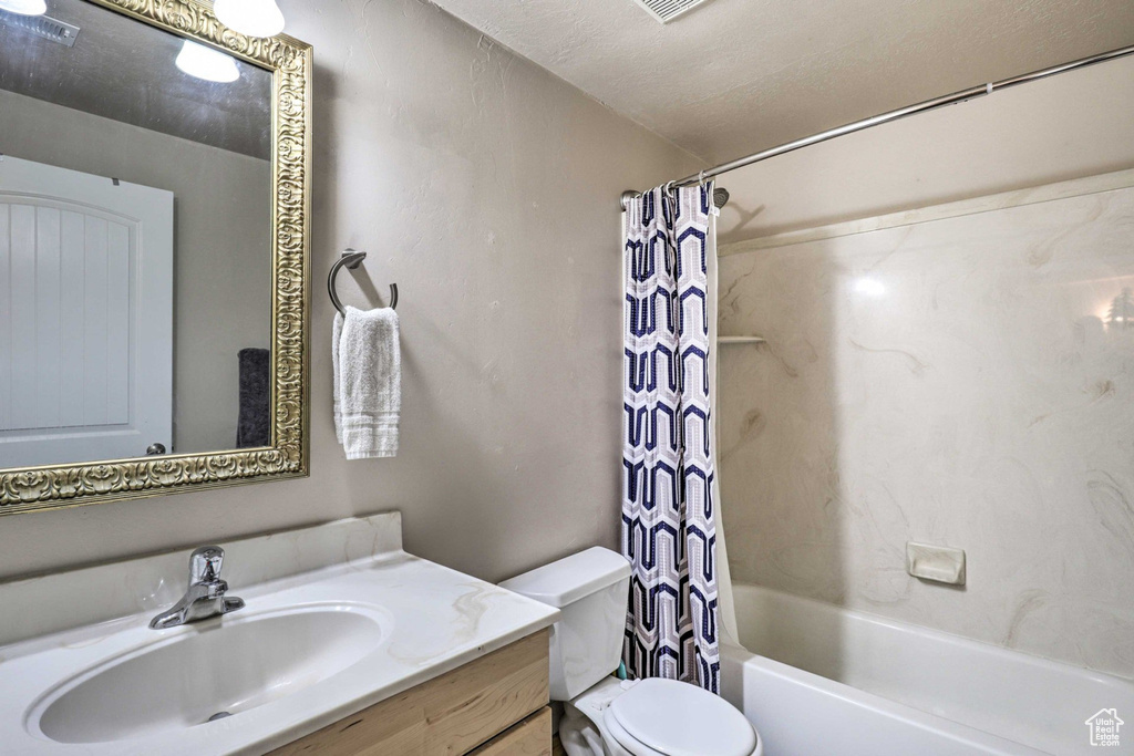 Bathroom featuring vanity and shower / bathtub combination with curtain