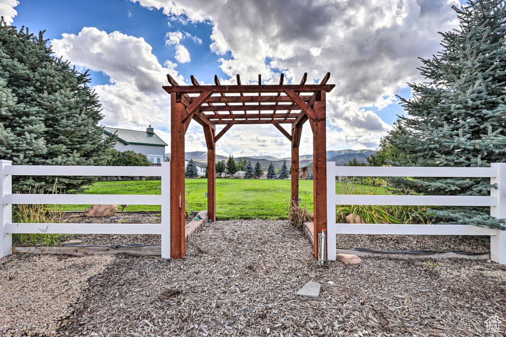 View of yard with a mountain view and a pergola