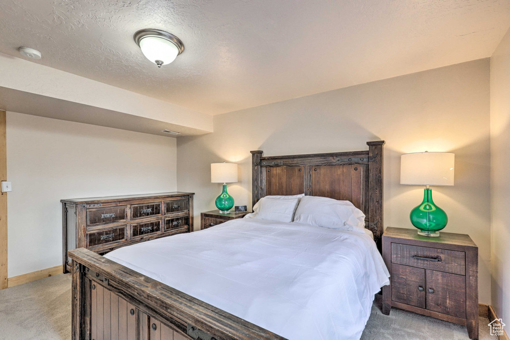 Bedroom featuring light carpet and a textured ceiling