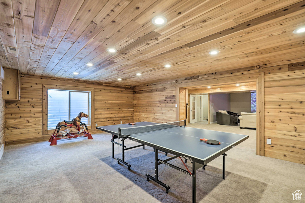 Rec room with carpet floors, wooden ceiling, recessed lighting, and wood walls