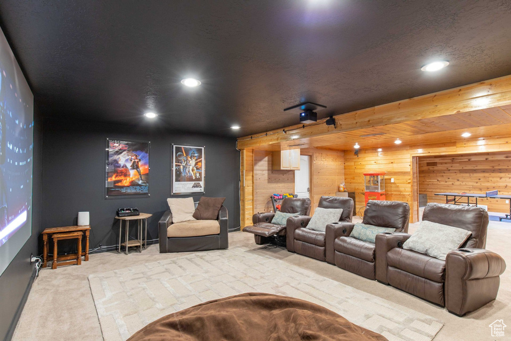 Carpeted home theater room with recessed lighting and wooden walls