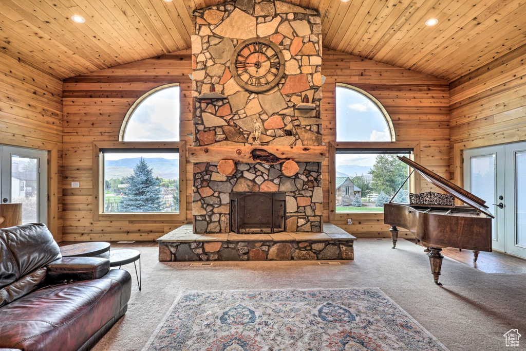 Living area featuring carpet, high vaulted ceiling, french doors, wooden ceiling, and wooden walls
