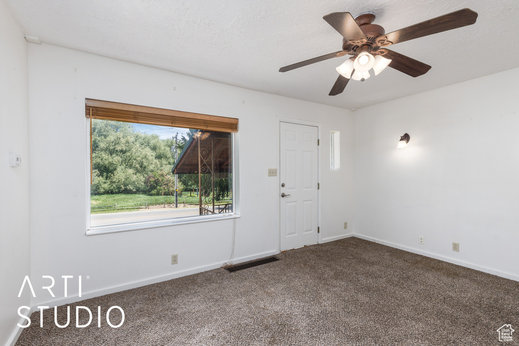 Entrance foyer with carpet and a ceiling fan