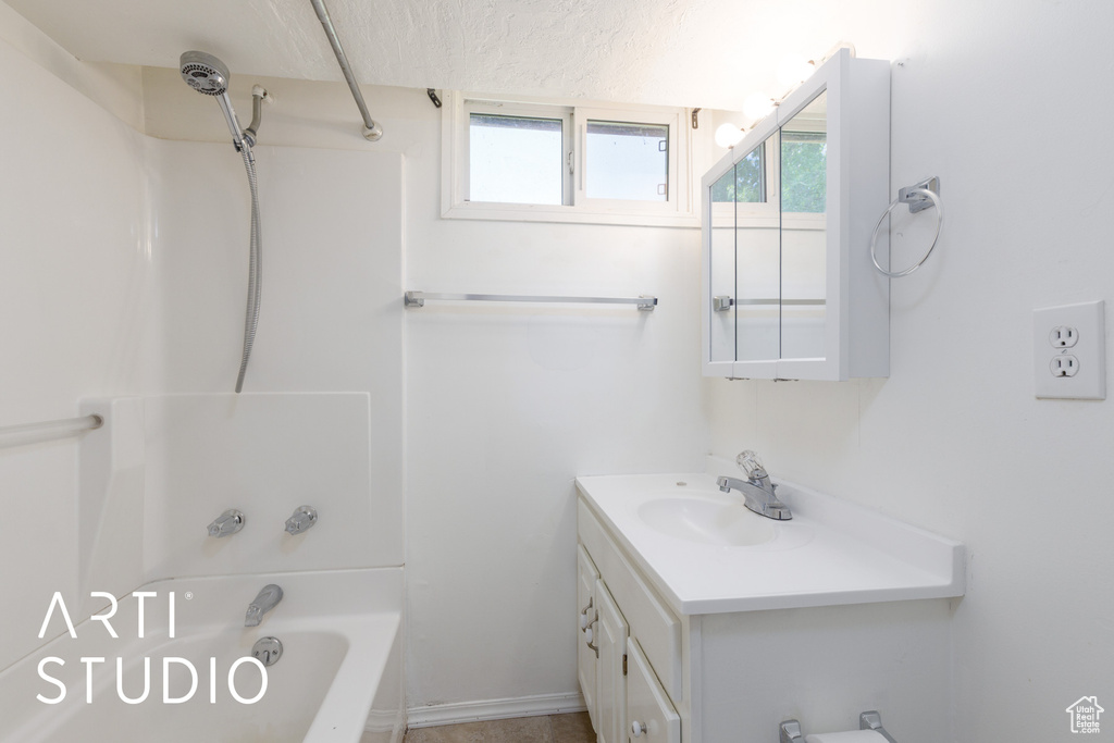 Full bathroom featuring vanity, shower / bath combination, healthy amount of natural light, and a textured ceiling