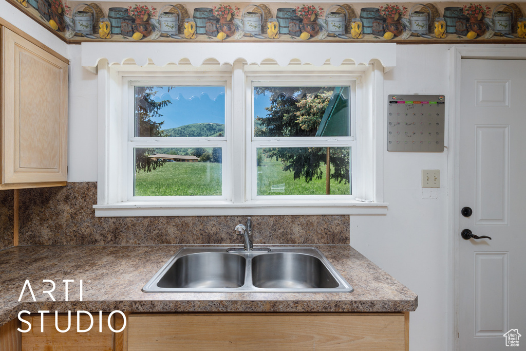 Kitchen featuring decorative backsplash and light brown cabinets