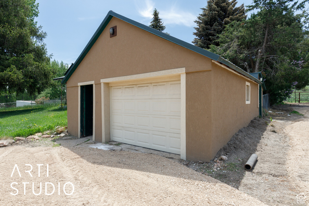 Detached garage featuring dirt driveway