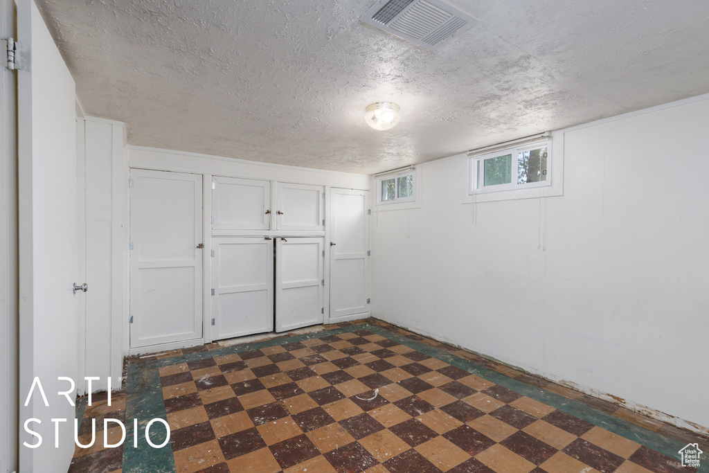 Basement with dark flooring and a textured ceiling