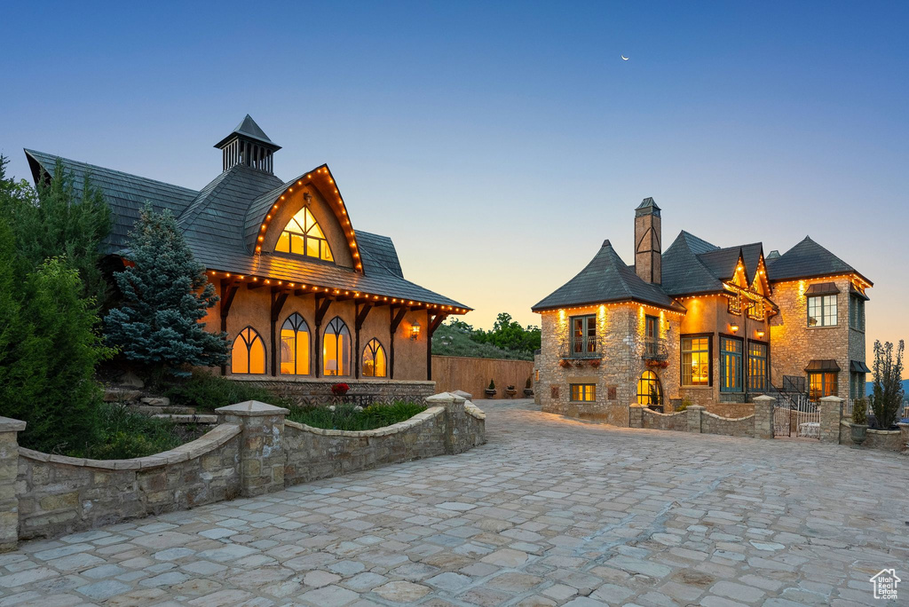 View of front facade featuring a chimney and stone siding