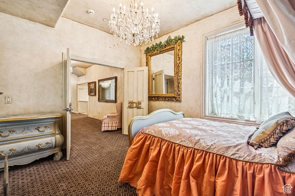 Carpeted bedroom featuring a chandelier