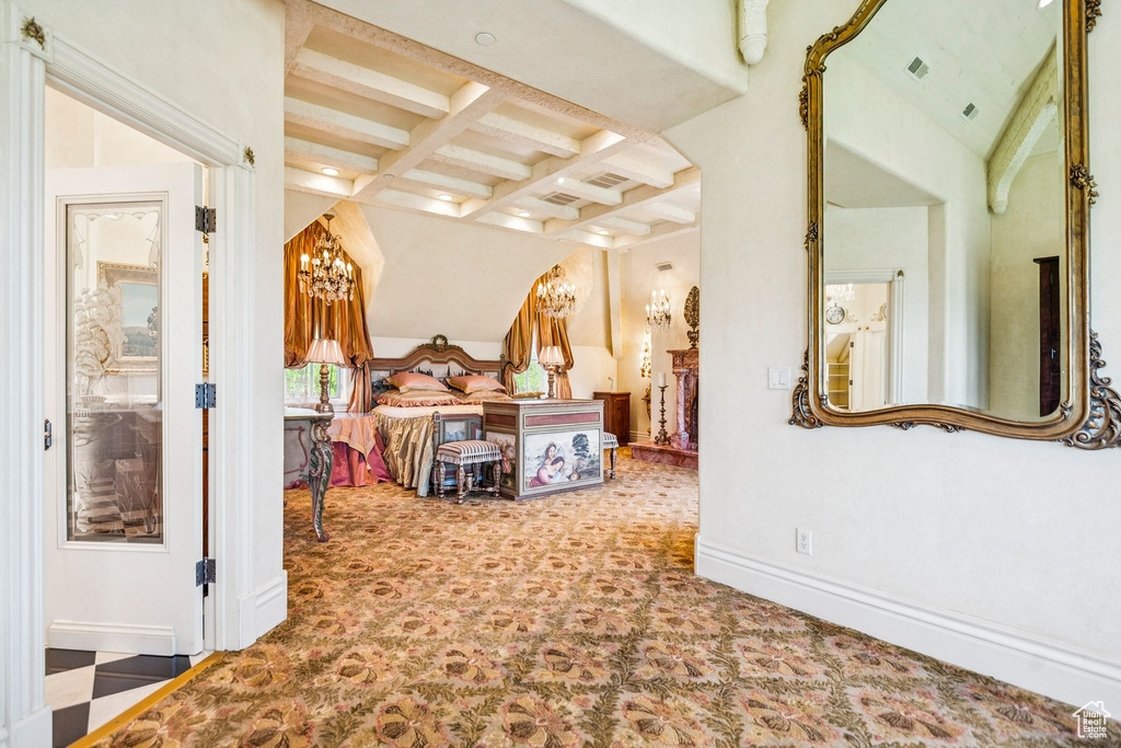 Bedroom with carpet floors, a chandelier, and beam ceiling