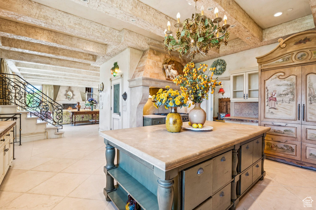 Kitchen featuring open shelves, decorative backsplash, light tile patterned floors, beam ceiling, and a center island