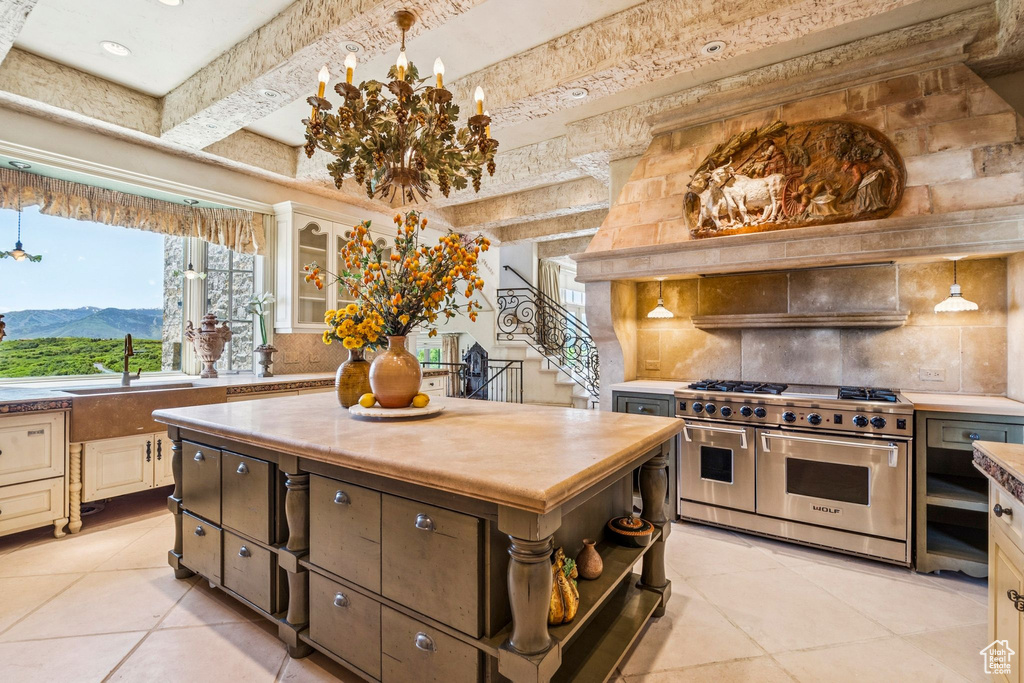 Kitchen with double oven range, backsplash, light tile patterned floors, butcher block countertops, and beam ceiling