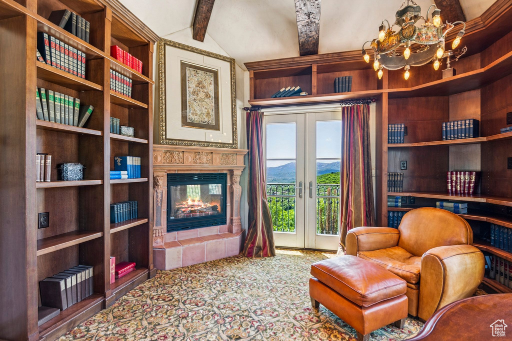 Sitting room with a tile fireplace, french doors, a chandelier, a mountain view, and carpet
