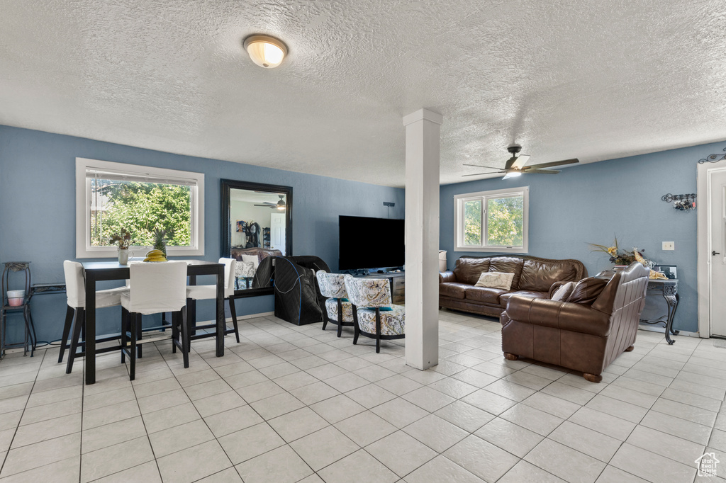 Living room featuring ceiling fan and a textured ceiling