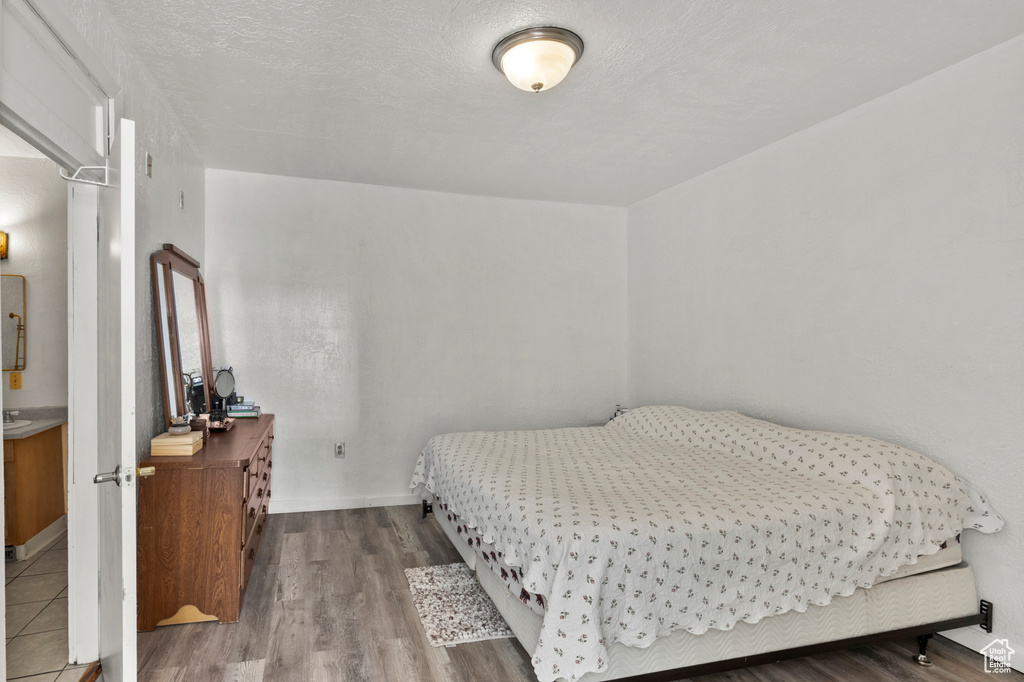 Bedroom with wood finished floors and baseboards