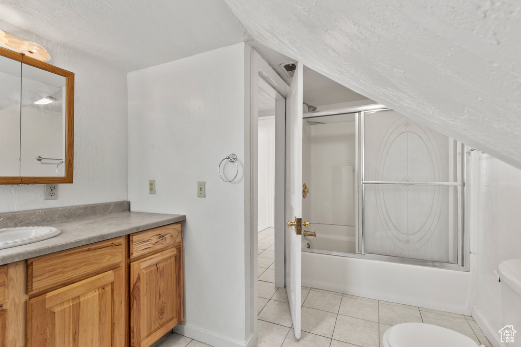 Bathroom featuring vanity, tile patterned floors, and bath / shower combo with glass door