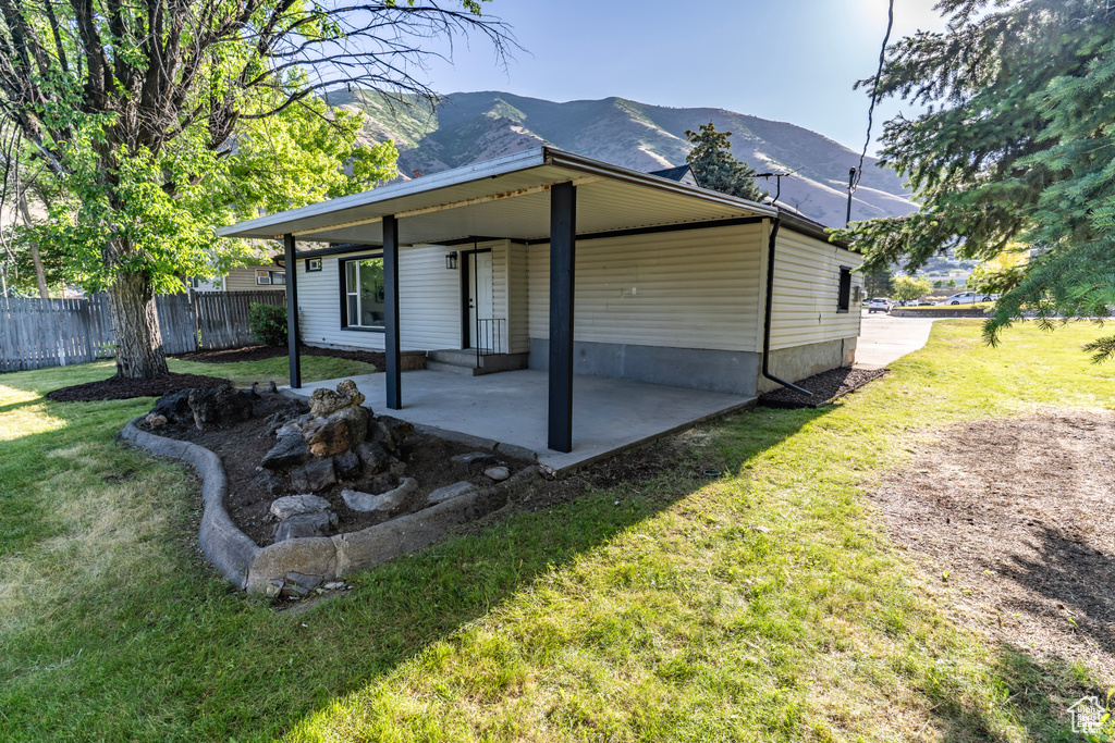 View of side of property with a mountain view and a patio area