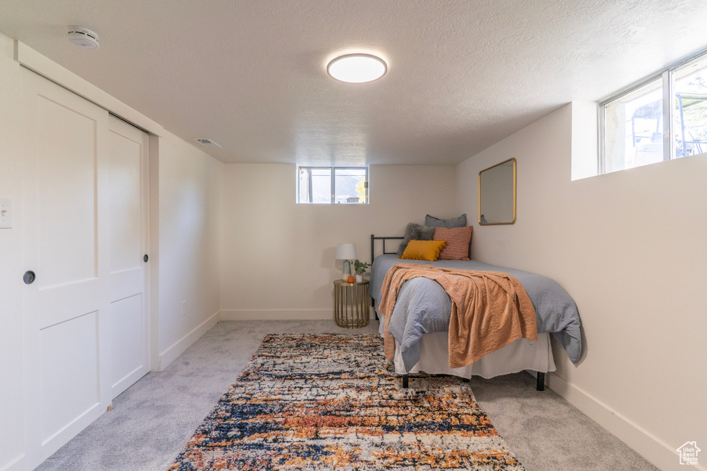 Bedroom with light carpet and a textured ceiling
