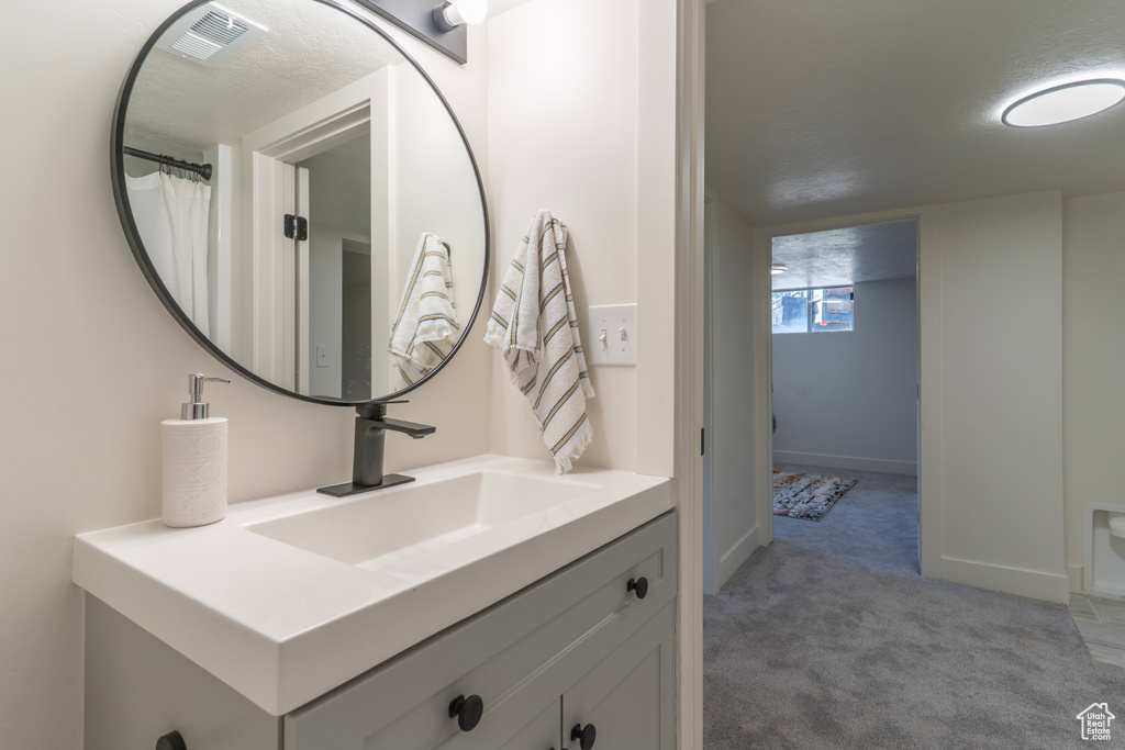 Full bath featuring vanity and baseboards