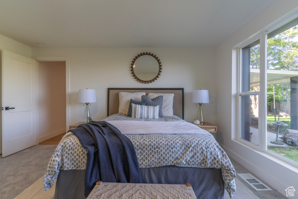 Carpeted bedroom featuring multiple windows