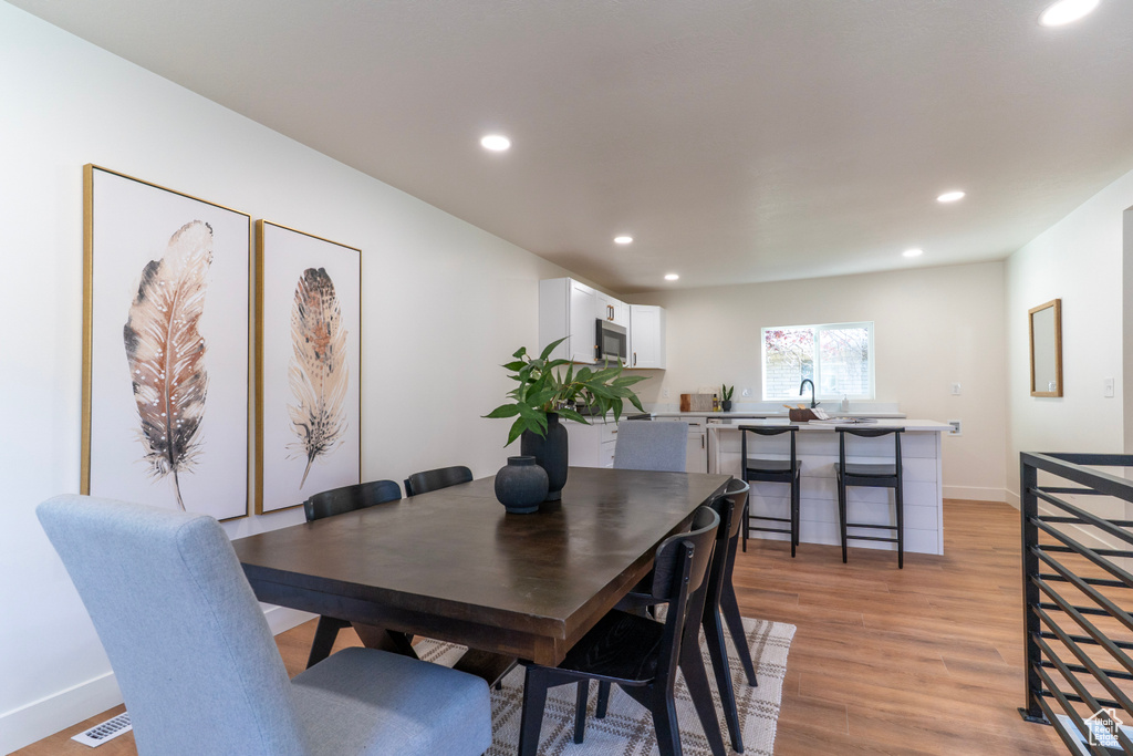 Dining room with recessed lighting and light wood-style floors