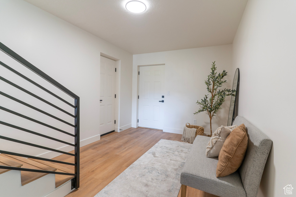 Foyer with stairs and light wood-style floors