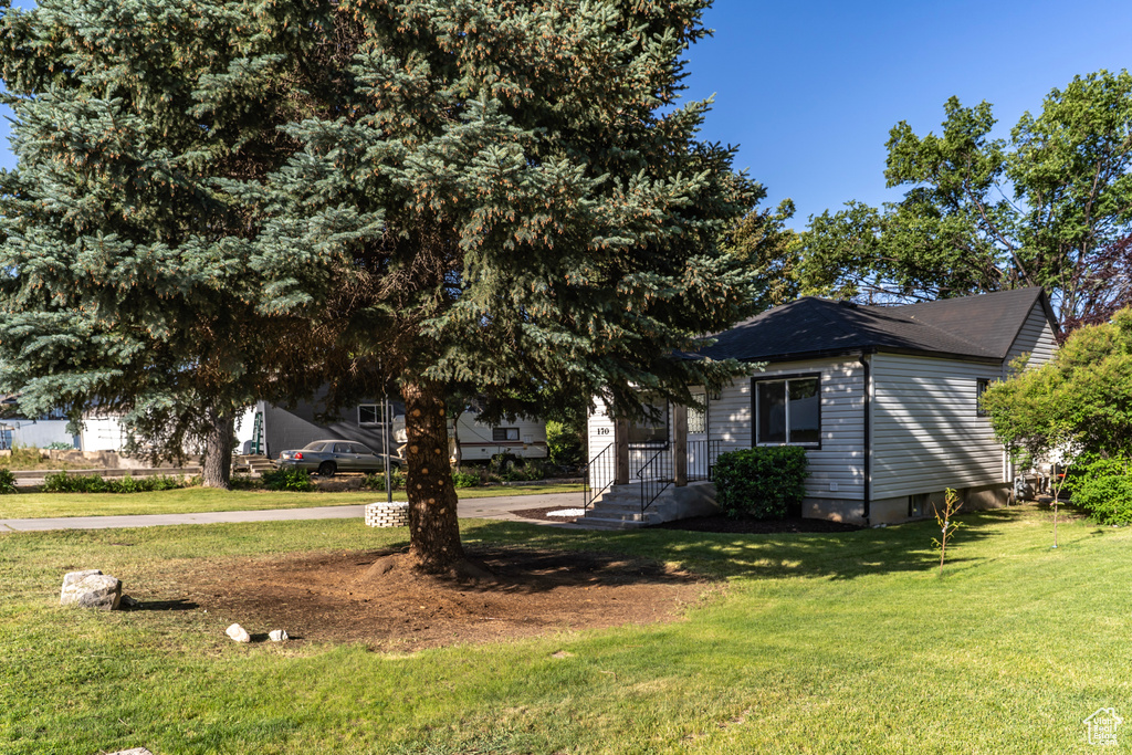 View of front facade with a front yard and a shingled roof