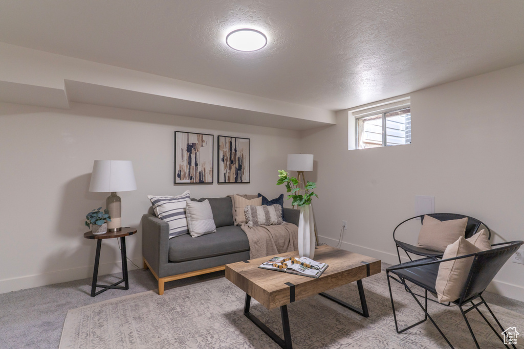 Living area with a textured ceiling and light colored carpet