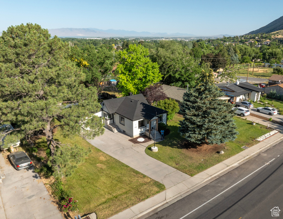 Drone / aerial view of a heavily wooded area and a mountain backdrop