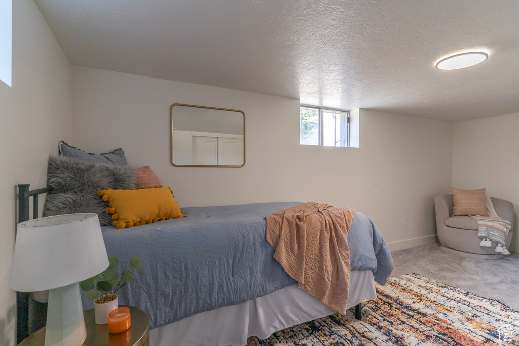 Carpeted bedroom with baseboards and a textured ceiling