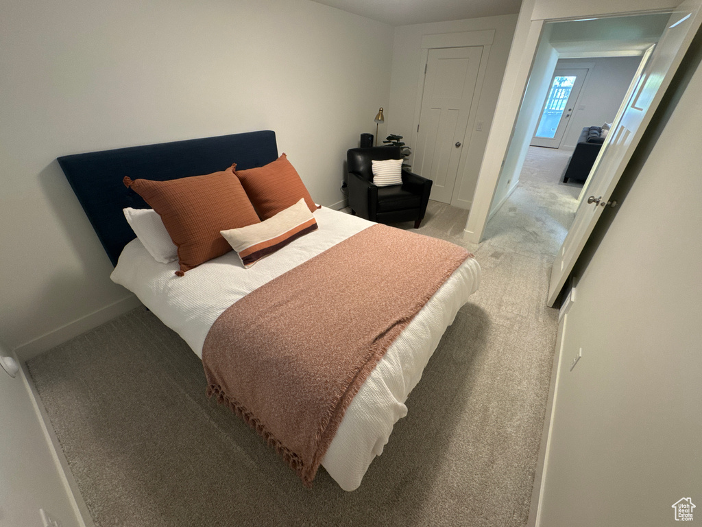 Bedroom featuring light colored carpet and baseboards