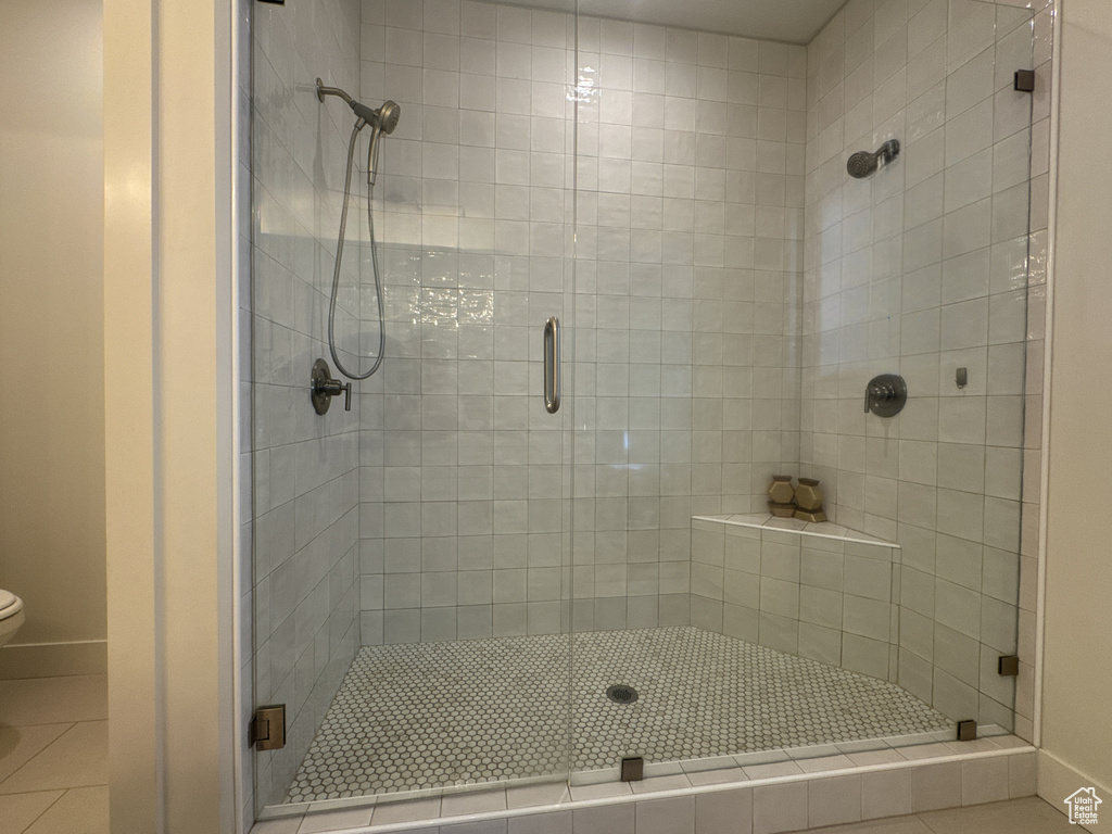 Bathroom with a shower stall and tile patterned flooring