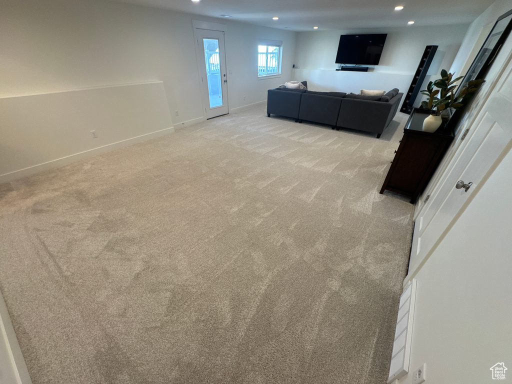 Living area featuring light colored carpet and recessed lighting