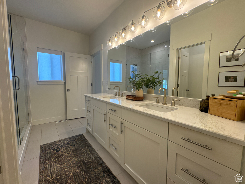 Full bathroom featuring double vanity, a shower stall, and tile patterned flooring
