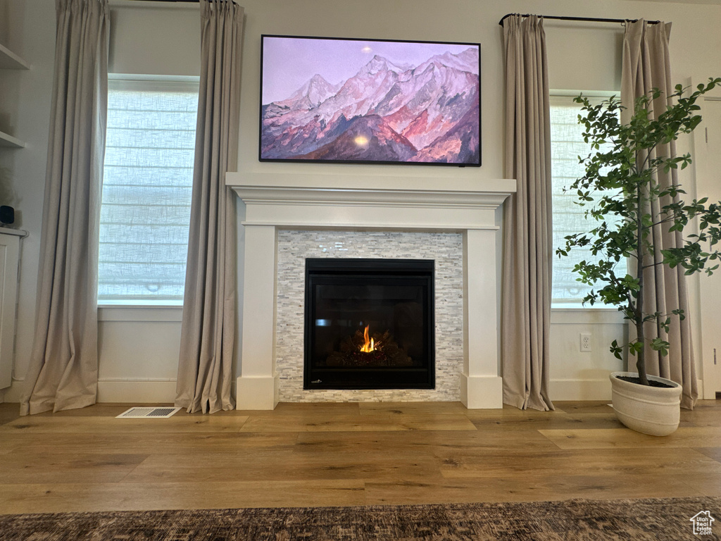 Detailed view of wood finished floors and a glass covered fireplace