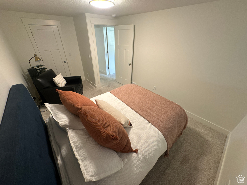 Bedroom with light carpet and baseboards